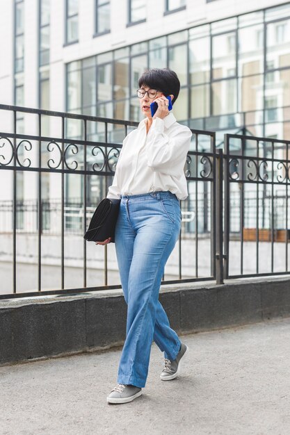 Businesswoman walking à côté d'un grand bâtiment