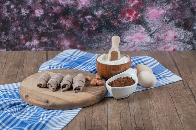 Cacao wrap mutaki cookies sur une planche de bois avec de la cannelle et des noix.