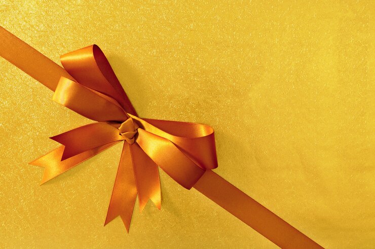 Photo gratuit cadeau d'or arc noël fond