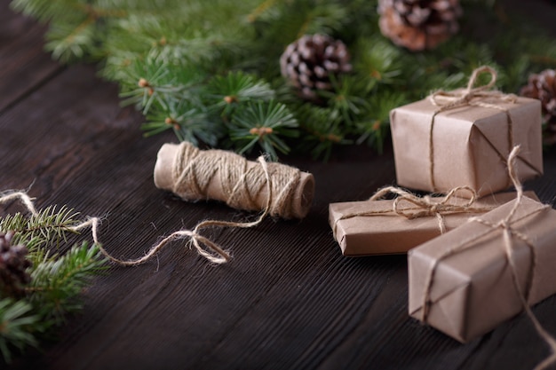 Cadeaux brun avec une chaîne et un rouleau de ficelle et de pin leaves