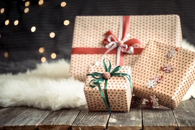 Photo gratuite des cadeaux de noël sur des lumières sur fond sombre. rubans colorés. décorations de joyeuses fêtes.