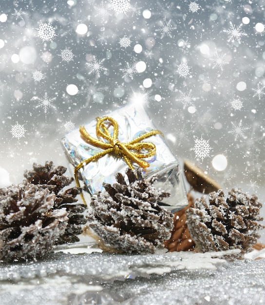cadeaux et des pommes de pin de Noël sur fond flocon de neige