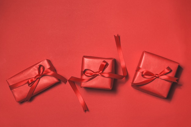cadeaux rouges avec une cravate rouge sur un fond rouge