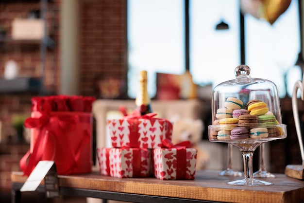 Cadeaux de saint valentin et biscuits macarons sur table, belles boîtes cadeaux emballées se bouchent. Célébration romantique du 14 février, jolies surprises festives de vacances pour petite amie. Fermer.