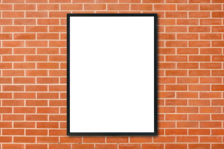 Photo gratuit un cadre d'affiche blanc accroché sur le fond d'un mur de briques rouges dans la pièce