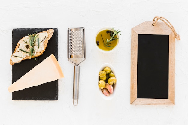 Cadre d&#39;ardoise en bois vide avec olive et fromage sur fond blanc