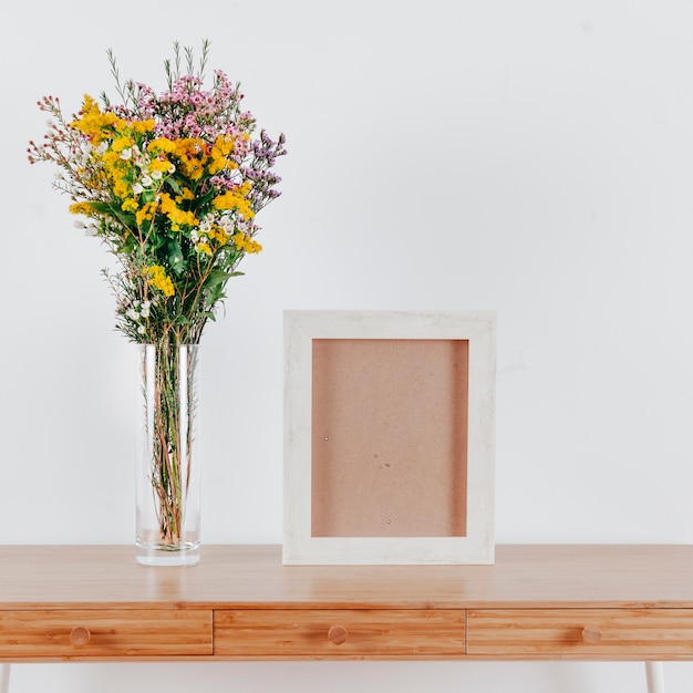 Photo gratuite cadre blanc près des fleurs