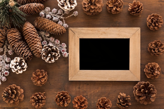 Cadre en bois avec des cônes sur la table