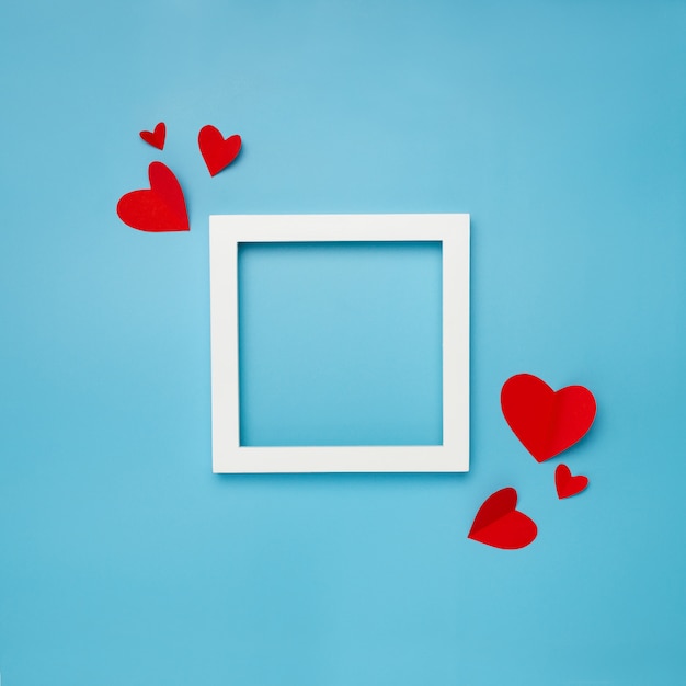 cadre carré blanc sur fond bleu avec des coeurs en papier