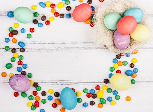 Cadre composé d&#39;œufs de Pâques et de petits bonbons