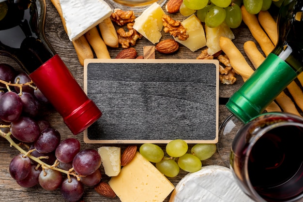 Cadre à côté de bouteilles de vin et de raisin et de fromage