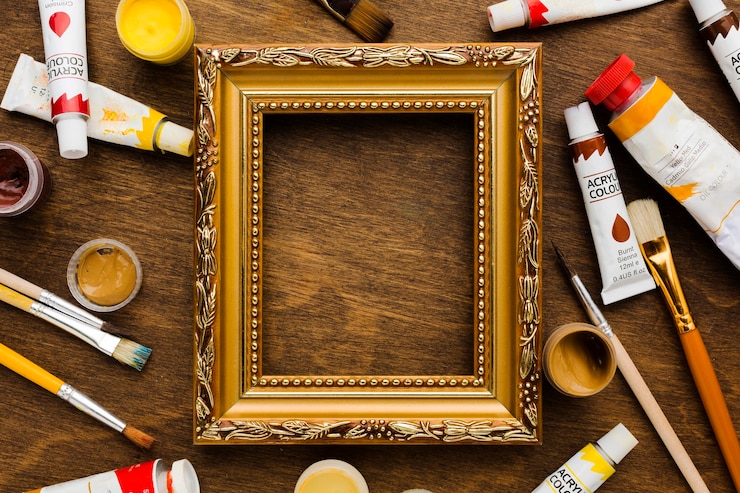 Photo gratuit cadre doré entouré de peinture et de pinceaux