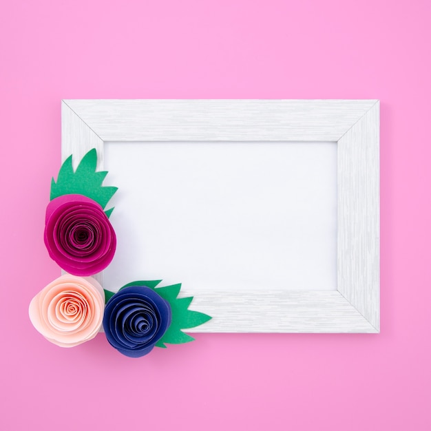 Photo gratuite cadre floral blanc sur fond rose