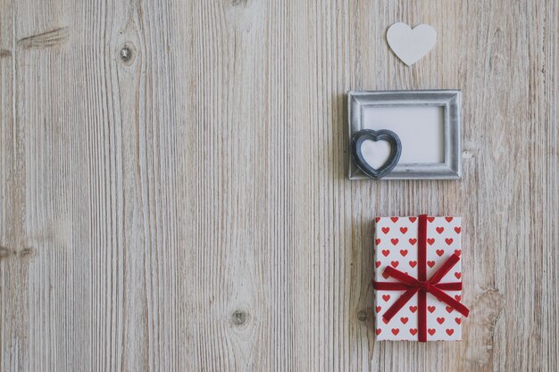 Photo gratuite cadre gris avec deux cadeaux et un coeur blanc