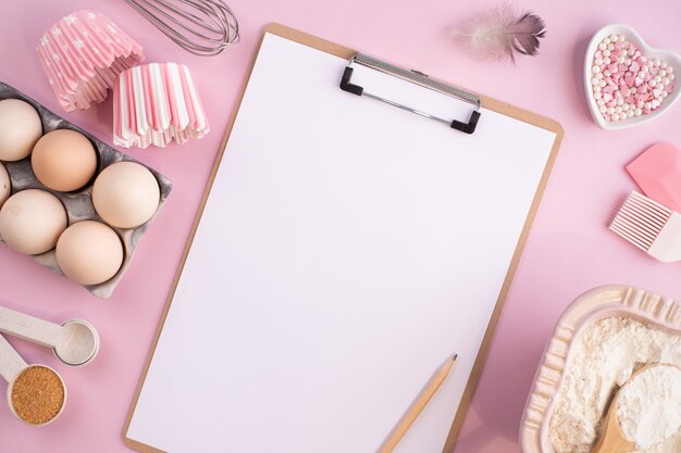 Cadre d'ingrédients alimentaires pour la cuisson sur un fond pastel légèrement rose. Cuisson à plat avec espace de copie. Vue de dessus. Concept de cuisson. pose à plat