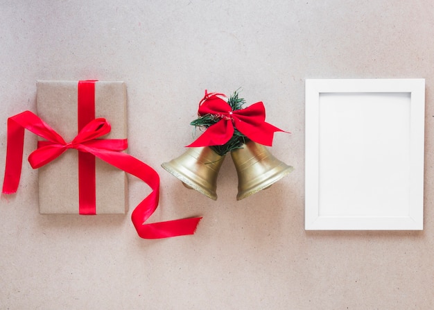 Cadre photo entre les cloches de Noël et la boîte cadeau