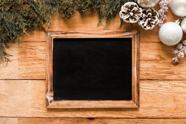 Cadre photo près de brindilles de conifères et de boules de Noël