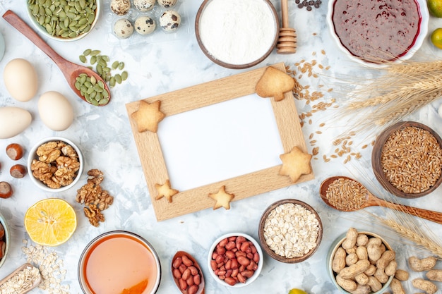 Cadre photo vue de dessus avec des œufs en gelée différentes noix et graines sur un gâteau de couleur pâte blanche photo sucrée tarte au sucre coeur de noix