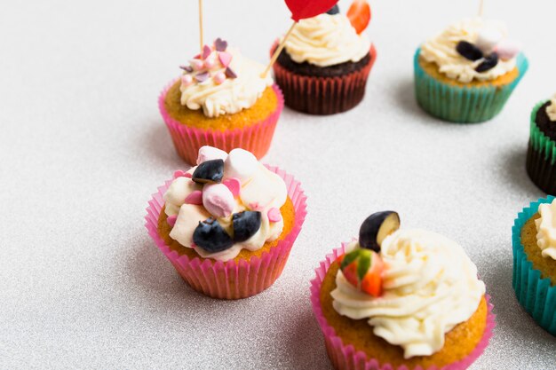 Cadre rond de petits cupcakes sur une table blanche