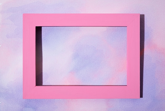 Photo gratuite cadre rose à plat sur fond peint à la main