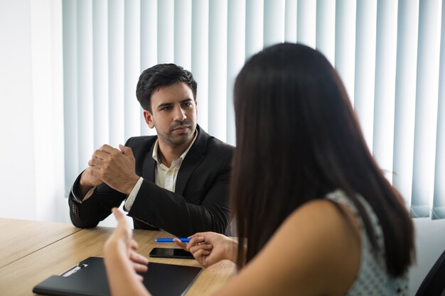 Cadre sérieux écoutant une partenaire ou une employée