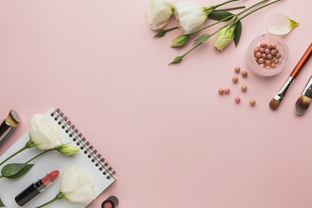 Cadre de vue de dessus avec des produits de maquillage et des fleurs