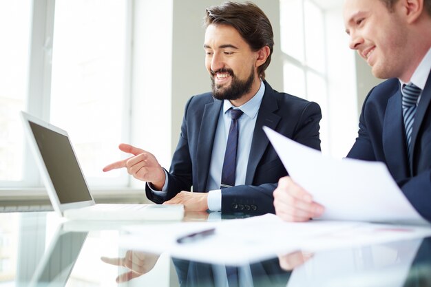 Les cadres qui travaillent ensemble sur un ordinateur portable