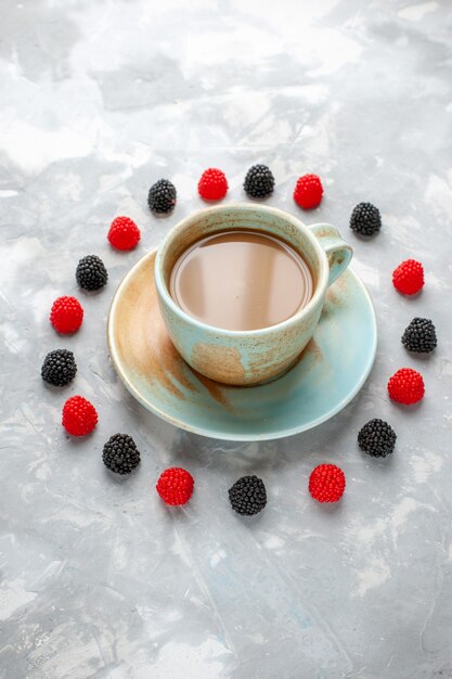 Café au lait avec des confitures de baies sur un bureau gris-blanc