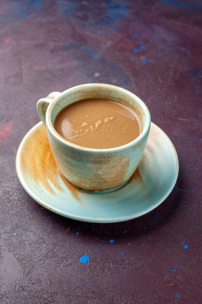 Café au lait à l'intérieur de la tasse sur un bureau de couleur aubergine foncé