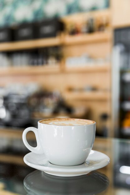 Café Cappuccino avec latte d&#39;art sur verre réfléchissant dans un café