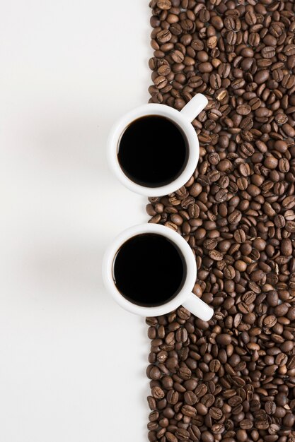 Café en grains torréfiés et tasses blanches de café