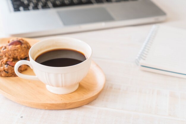 Café noir et biscuits avec ordinateur portable et cahier