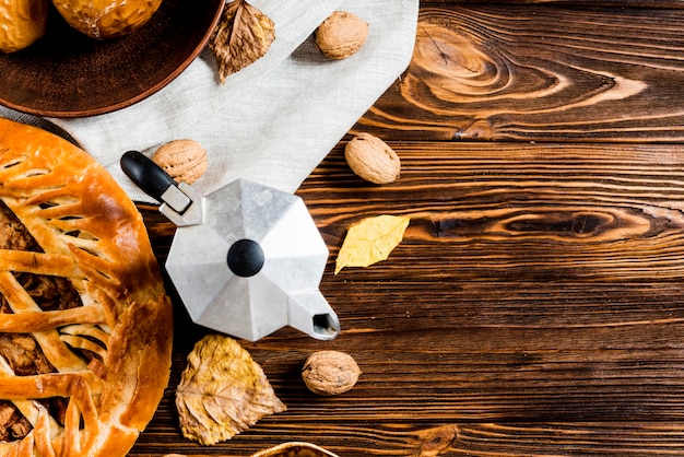 Cafetière près des feuilles et des collations