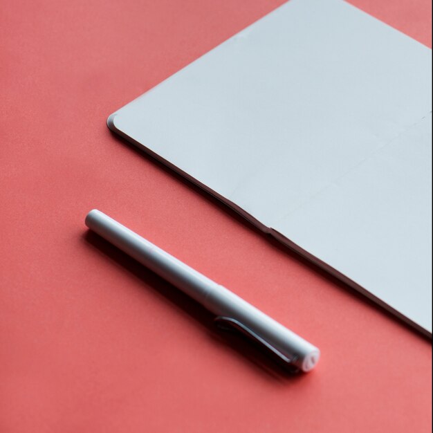 Cahier blanc et stylo isolé sur fond