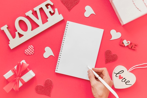 Photo gratuite cahier avec la main et un stylo pour la saint valentin