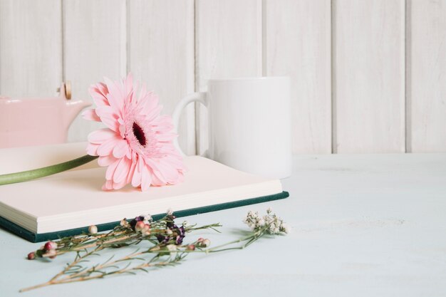 Cahier ouvert avec fleur près de la tasse