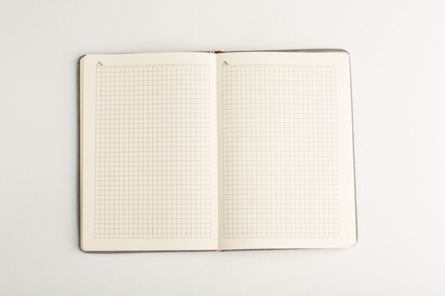 Cahier ouvert vue de dessus sur surface blanche