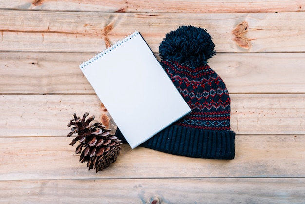 Photo gratuite cahier près du chapeau à pompon