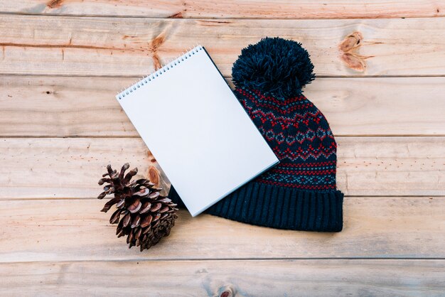 Cahier près du chapeau à pompon