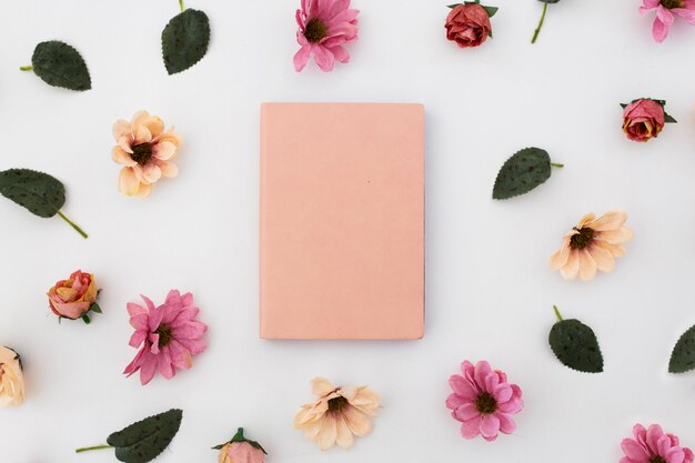 cahier rose avec motif de fleurs sur fond blanc