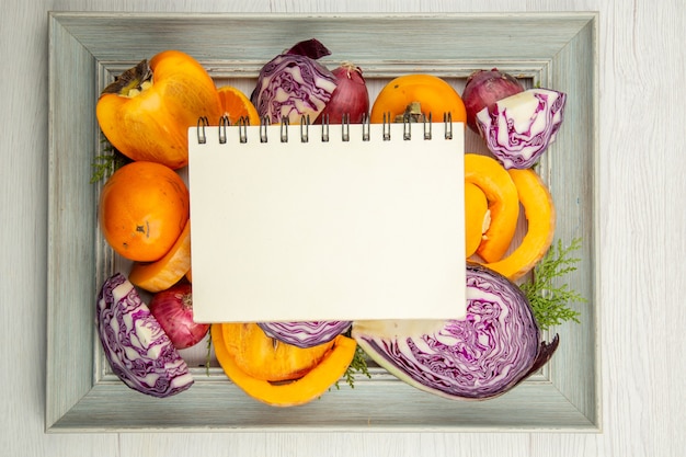 Cahier vue de dessus sur les fruits coupés sur fond gris du cadre