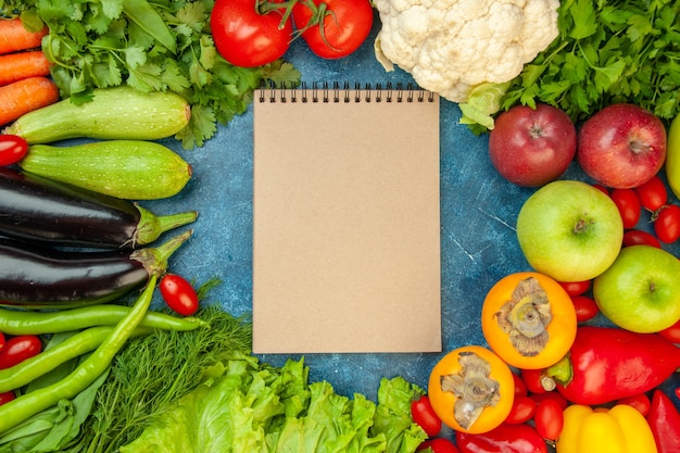 Photo gratuite cahier vue de dessus avec fruits et légumes sur fond bleu