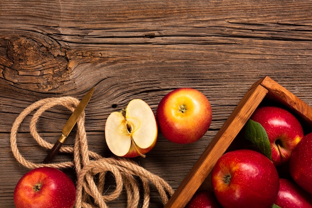 Photo gratuite caisse plate avec des pommes mûres avec une corde