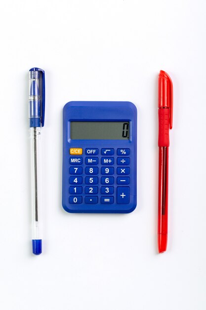 Calculatrice bleue utilisation de la main comptable pour les affaires avec deux stylos une vue de dessus sur blanc