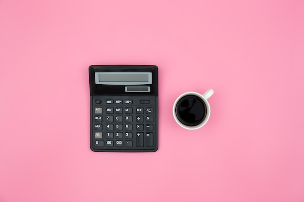 Photo gratuite calculatrice et une tasse de café sur fond rose