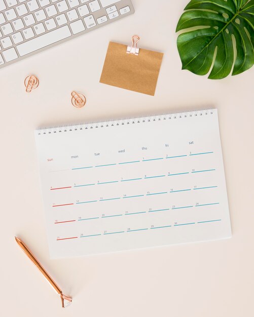 Calendrier de bureau plat laïque avec feuille de monstera et boîte à crayons