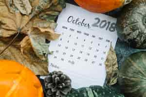 Photo gratuite calendrier d'octobre 2018 entre citrouilles et feuilles