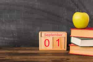 Photo gratuite calendrier près de la pomme et des livres