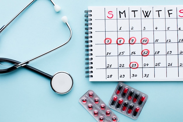 Photo gratuite calendrier de traitement médical avec stéthoscope et pilules