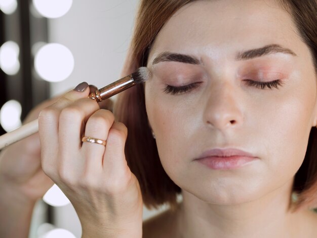 Calme beau modèle de maquillage se bouchent